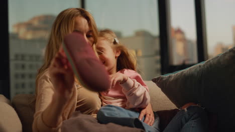 Cheerful-mother-and-daughter-hugging-at-home.-Woman-and-girl-relaxing-indoors.