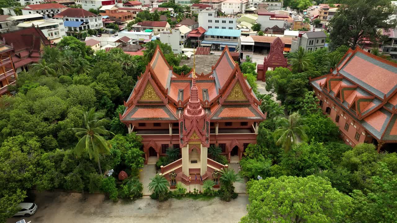 Cambodian temple rooftops framed by lush green urban scenery