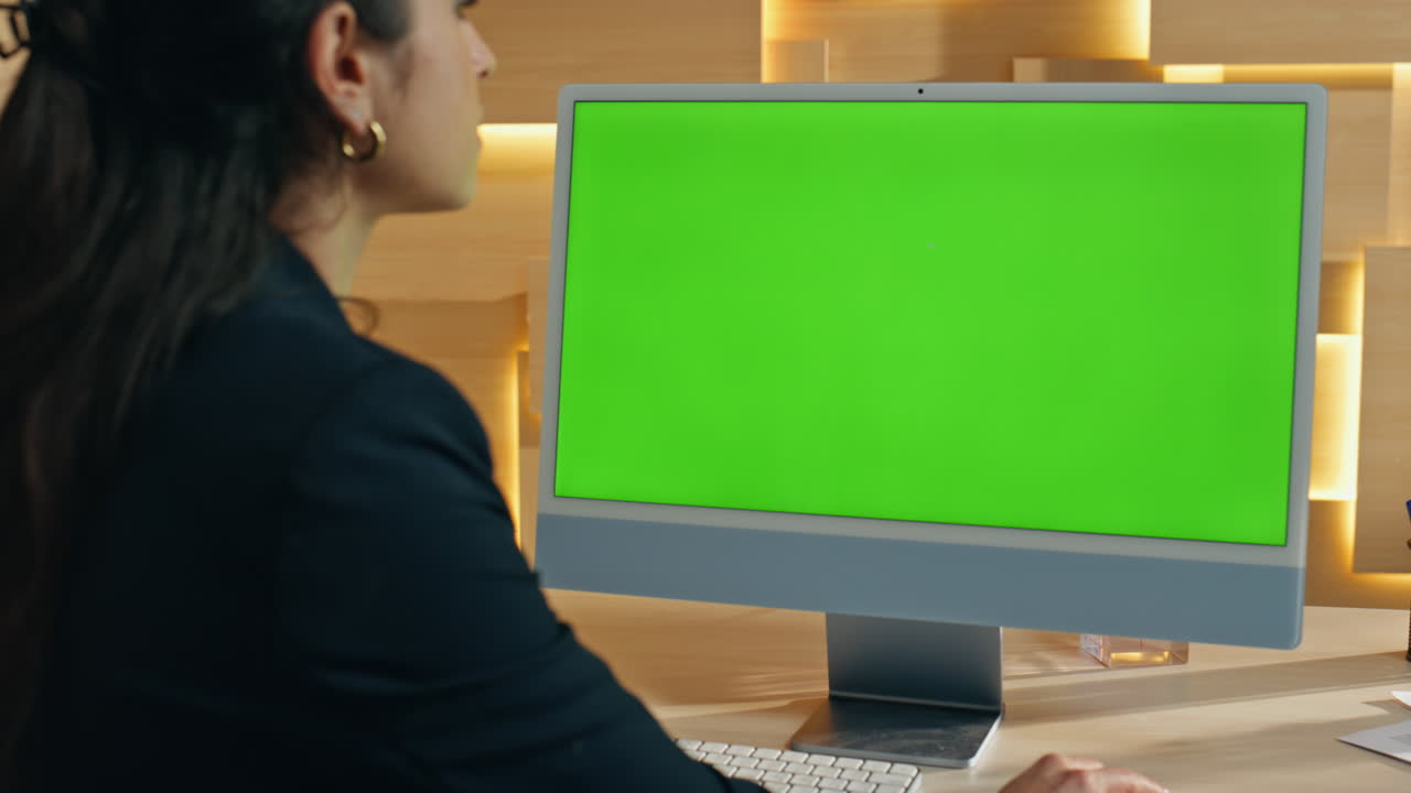Woman Working at a Computer with Green Screen