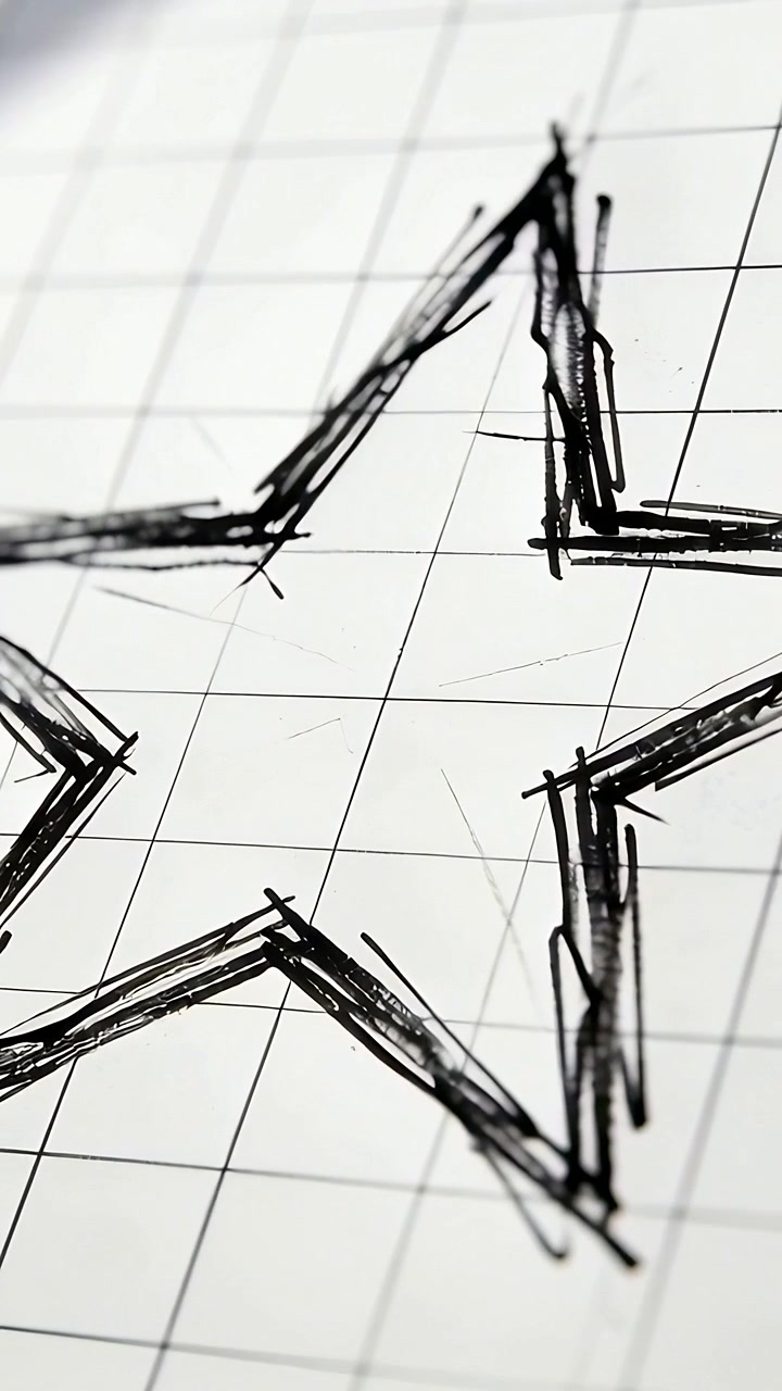 Video vertical: Cámara panorámica revelando una estrella de cinco puntas en papel cuadriculado, mostrando trazos de tinta superpuestos