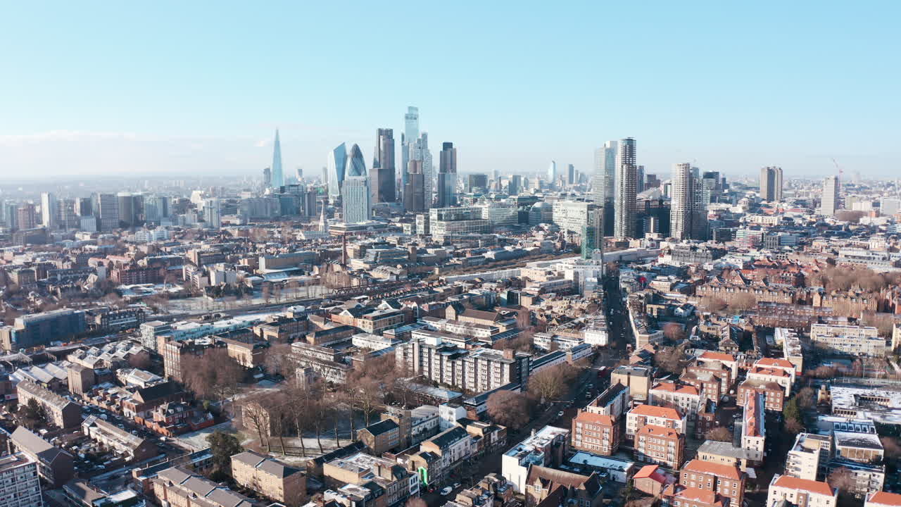 눈이 내린 후 맑은 날 타워 햄릿에서 런던 고층 빌딩의 도시 위로 높은 드론 샷 상승