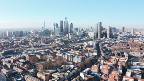 eine hoch aufsteigende drohne schoss über die wolkenkratzer der city of london aus den tower hamlets, klarer tag nach dem schnee