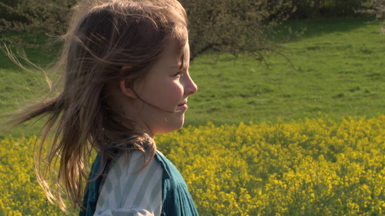 Happy little girl putting on a winter hat in the wrong direction. Nature Scenery.