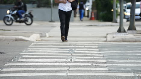 Pedestrian-crossing-a-street-by-the-crosswalk-of-a-big-city-in-daylight-filmed-in-slow-motion-in-4K-high-definition