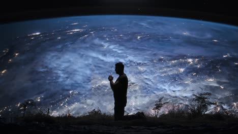 man praying to earth from space