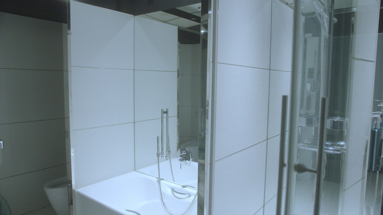 Beautiful, slightly moving shot of the jacuzzi and shower of an elegant bathroom inside a 5-star luxury hotel room in Spain.