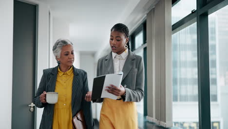 two businesswomen discussing a report in a modern office