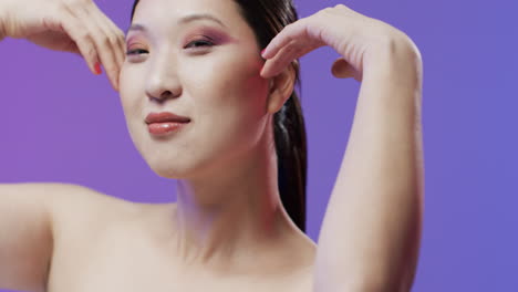 asian woman with black hair and make up smiling camera, copy space, slow motion