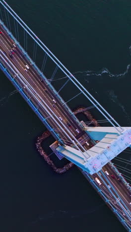 massive huge bridge over the deep river. view from top on the bridge with transport moving quickly. vertical video