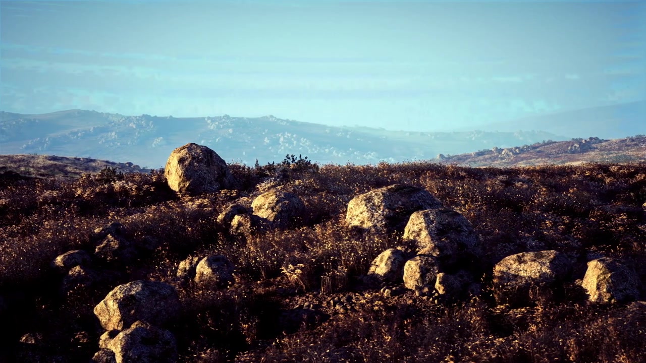 Immagine cinematografica rilassante con rocce aspre e vaste catene montuose.