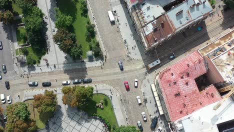 Aerial-topdown-of-cars-driving-on-the-road-in-Lviv-Ukraine-during-a-sunny-summer-day-surrounded-by-old-European-buildings