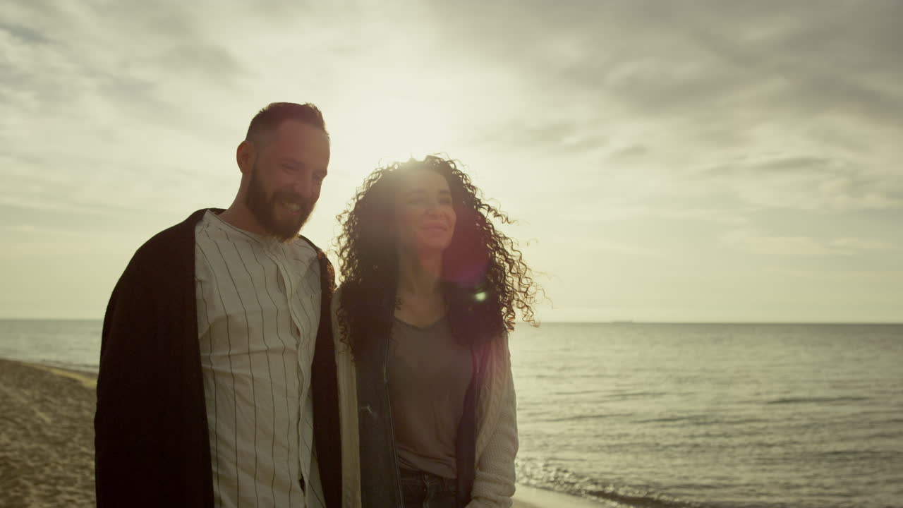 자연과 바다 풍경에서 해가 지는 해변을 즐기는 커플. 밖에서  ⁇ 는 두 사람.