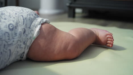 baby boy moves his legs around while attempting to learn how to crawl