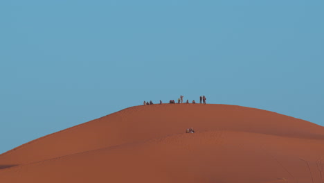 Eine-Düne-In-Merzouga,-Marokko-Mit-Ein-Paar-Leuten-Im-Hintergrund