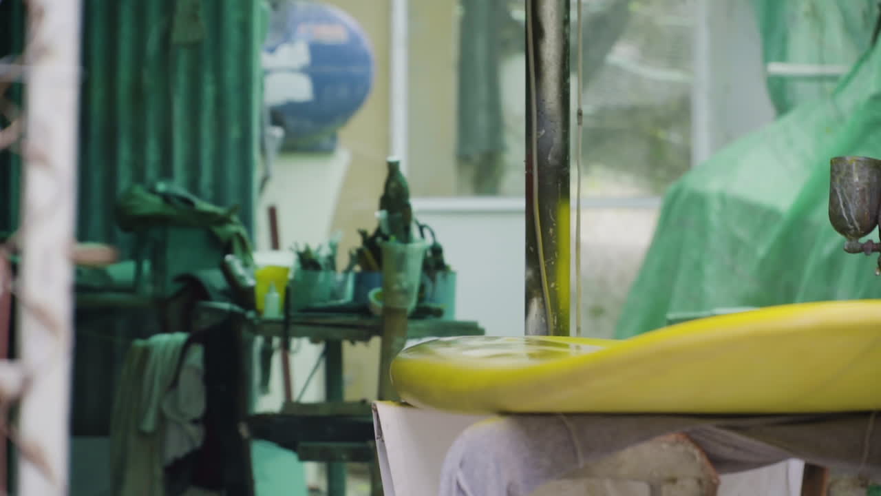 pintor aplicando una capa de pintura amarilla a través de una pistola de pintura en aerosol presurizada