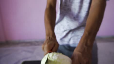 young man cutting cabbage for salad