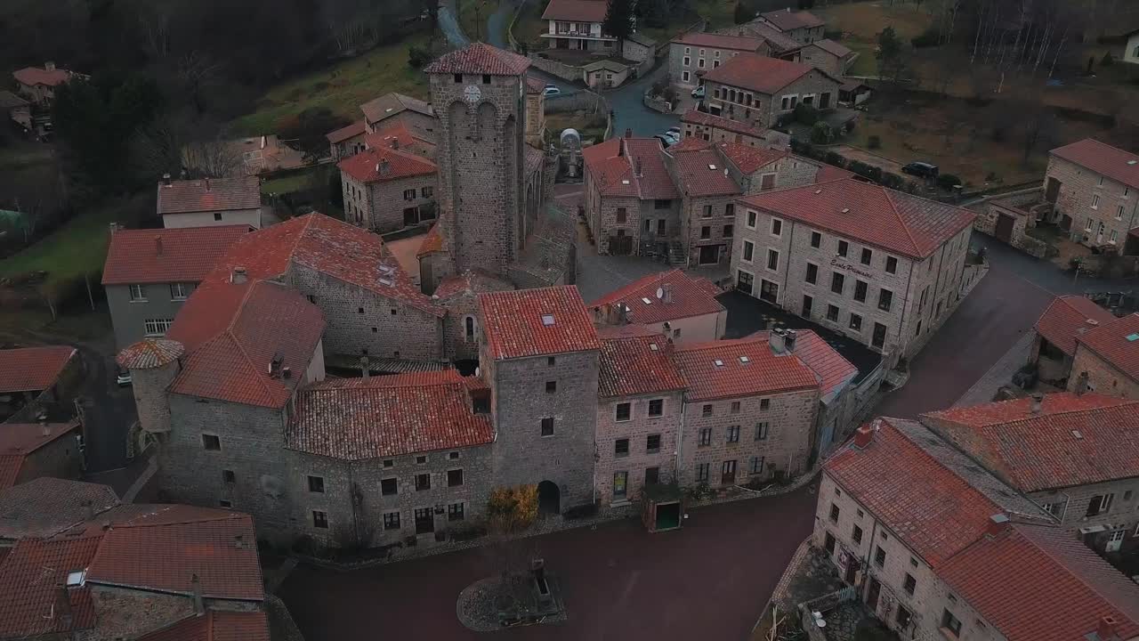 aerial shot over the town of Marols in Loire departement on an overcast day revealing the fortified church and the landscape, Auvergne Rhone Alpes region, France