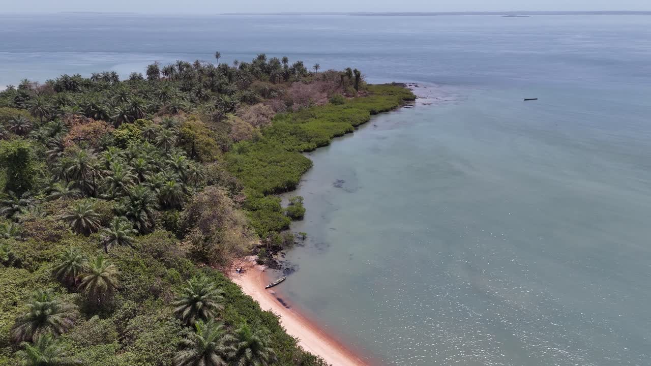 Aerial view of the colorful coastline with pink sands in Bijagós Archipelago, Guinea-Bissau, surrounded by lush greenery