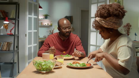 black family couple chatting over dinner at home