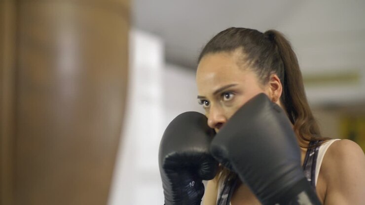 Primo piano di pugile che colpisce il sacco da boxe
