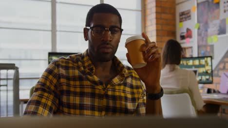 male graphic designer drinking coffee and using laptop 4k