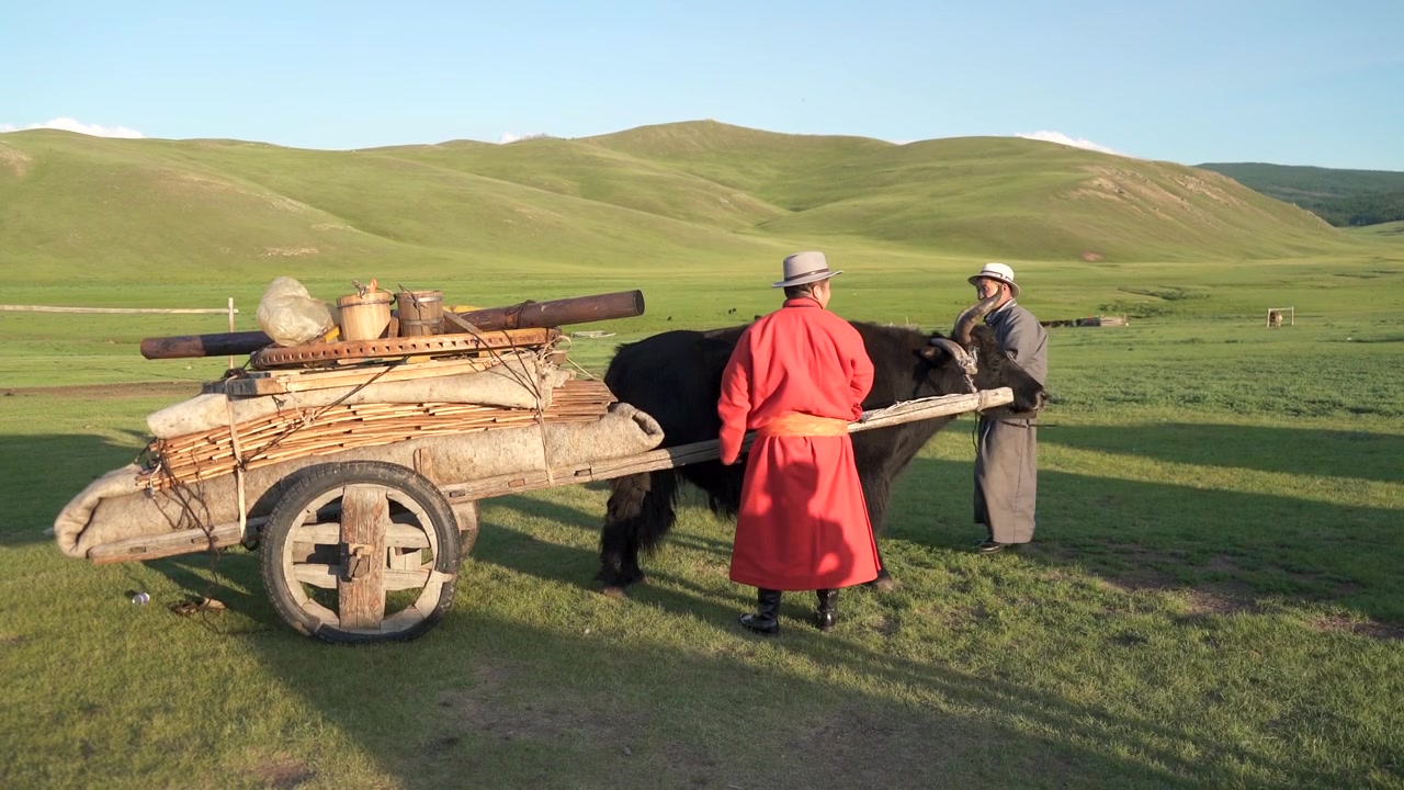 Mongolske nomader med jakokse og tradisjonell trekjerre på steppen