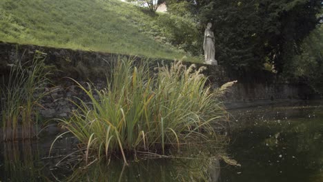 ducks swimming in-front of antique statue along pool in stadt park in graz, austria