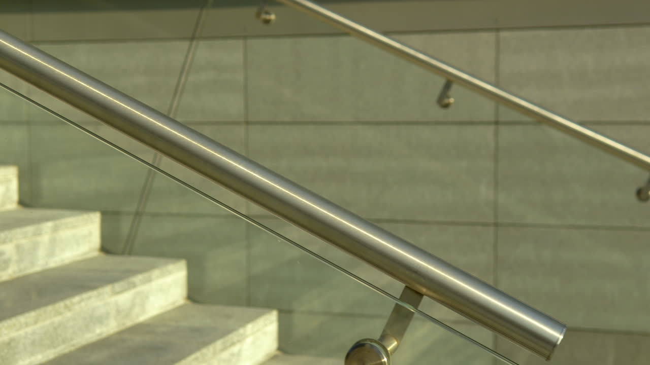 primer plano de barandillas de acero inoxidable con paneles de vidrio, elementos de diseño de escaleras modernas