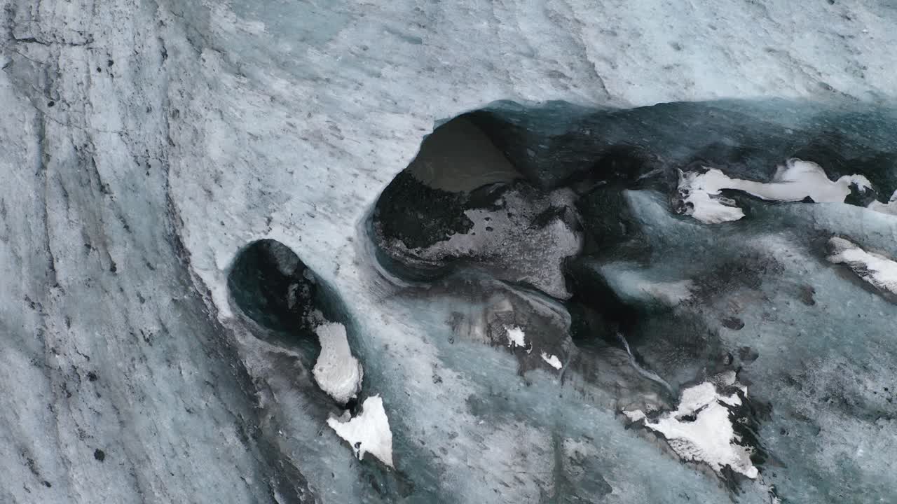 toma ascendente de arriba hacia abajo del glaciar de la cueva de hielo de color azul y el agua que fluye en islandia