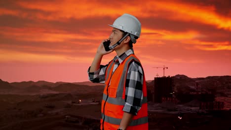 ingeniero de construcción hablando por teléfono durante el atardecer.