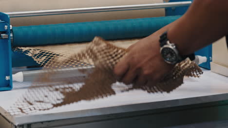 close-up of hands dispensing eco-friendly honeycomb paper packaging