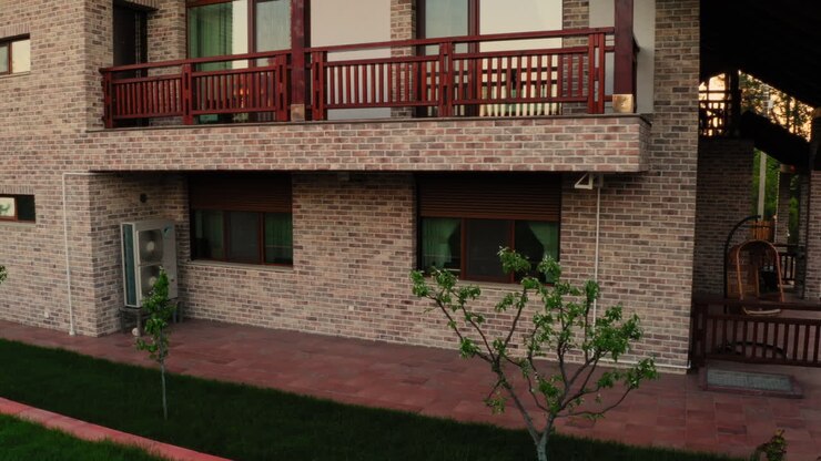 Åbnende rulleskodder på et luksuriøst, moderne hus i en landsby i Moldova om morgenen