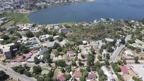 a drone tilt-up shot transitions from suburban houses to the expansive view of lake victoria in africa. captures the harmony between urban living and the breathtaking beauty of the lake.