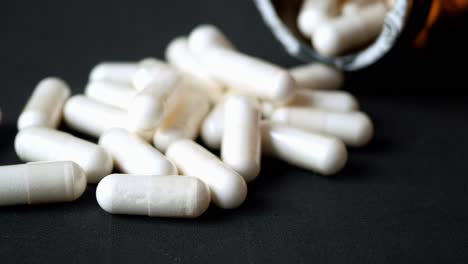 white capsules on dark surface