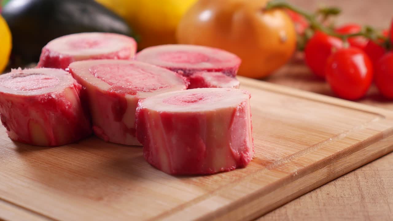 Raw Bone Marrow on a Wooden Cutting Board with Vegetables