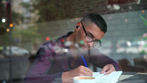 Hispanic-male-entrepreneur-reading-notes-in-cafe