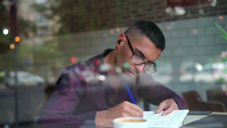 hispanic male entrepreneur reading notes in cafe