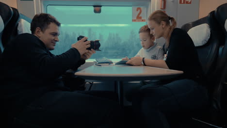 shooting video of mom and child using pad during train ride