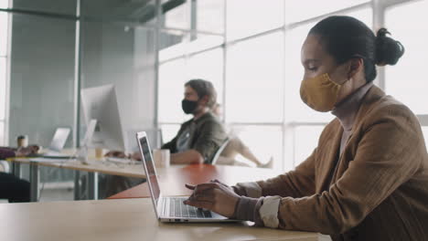 business people working in office space wearing masks