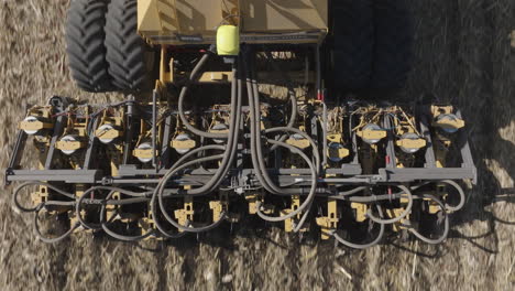 strip till machine operating on a farm field, performing strip tillage, aerial top down