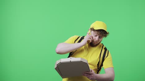 retrato de hombres jóvenes hablando por teléfono deja caer una caja de pizza y está muy molesto. hombre pelirrojo en uniforme de mensajero de entrega amarillo con bolsa térmica posando en pantalla verde. primer plano. cámara lenta lista 59.97fps