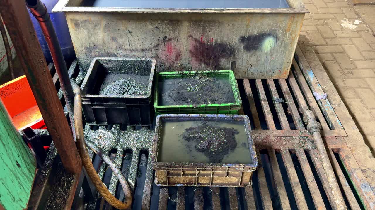 Dirty wastewater sludge collected in bins at an industrial facility, illustrating pollution and environmental waste management
