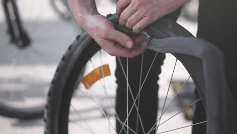 a bike wheel being equiped with a new tube by a bike mechanic