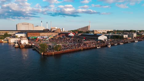 aerial view of a summer waterfront festival with a large crowd