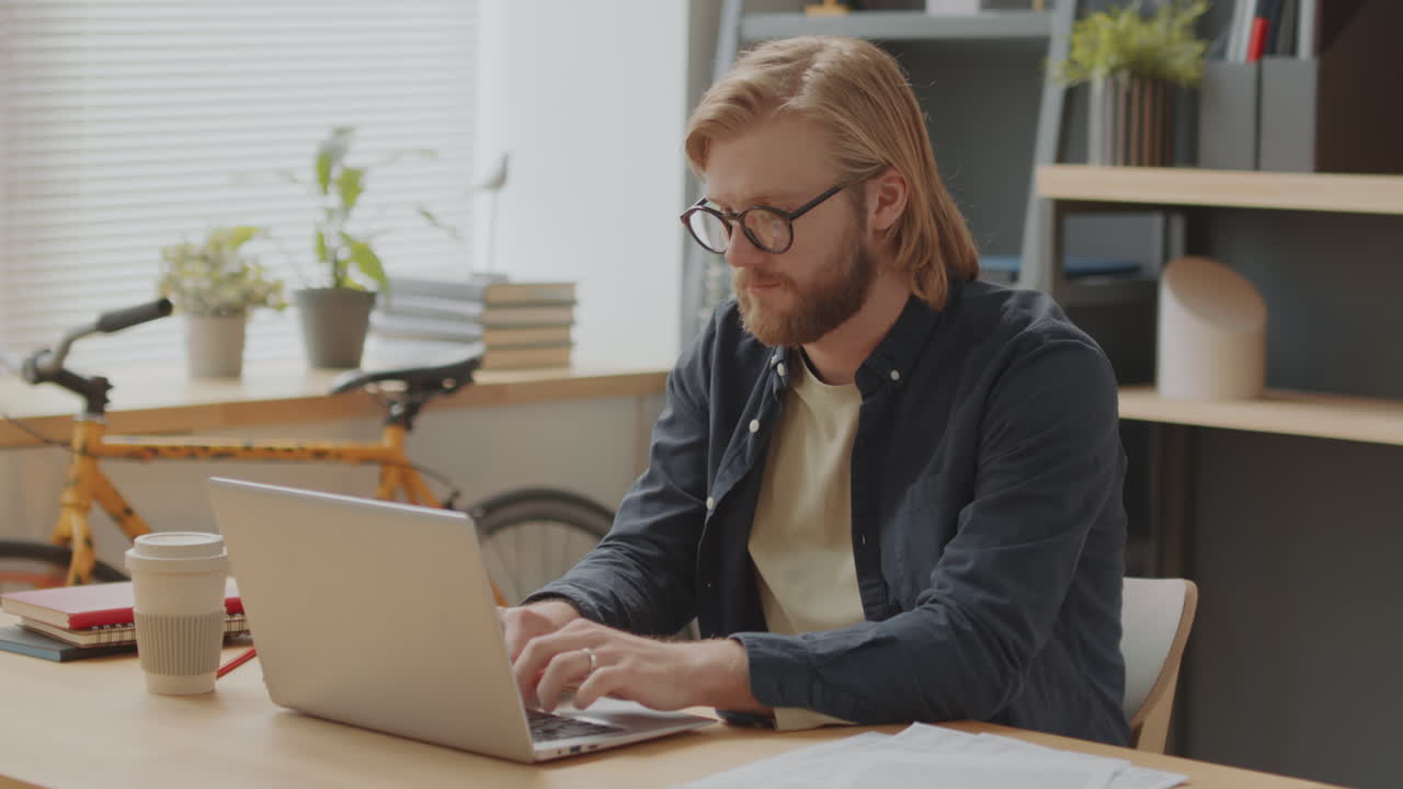 Young Man Working on Laptop in Office