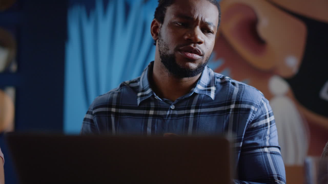 Annoyed afro man crumpling paper. Disappointed guy throwing document in office