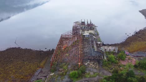 edificio abandonado de la gama de torpedos en loch long cerca de arrochar, tierras altas escocesas, costa oeste de escocia - filmación aérea de drones 4k hd, salida aérea