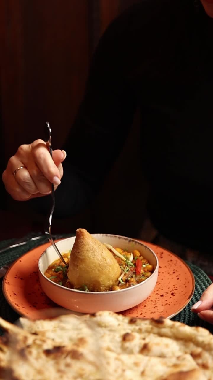 Eating Indian food with samosa and curry