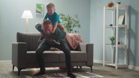 young man plays with young man plays with child in bright room in blue tones