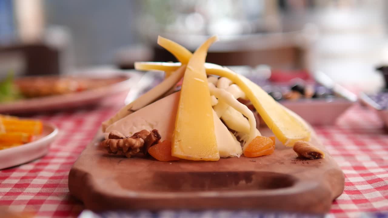 Assorted Cheeses and Nuts on a Wooden Board